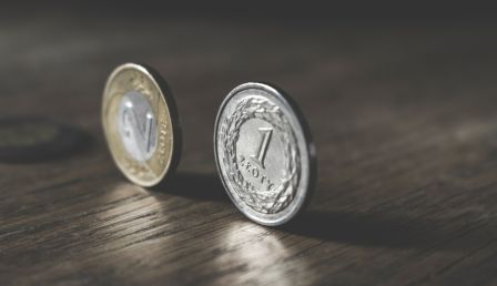 Photo of Two Gold-colored and Silver-colored Coins Standing on Floor